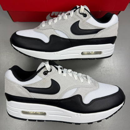 Nike Air Max 1 white trainers with pure platinum and black accents, classic logo detailing.