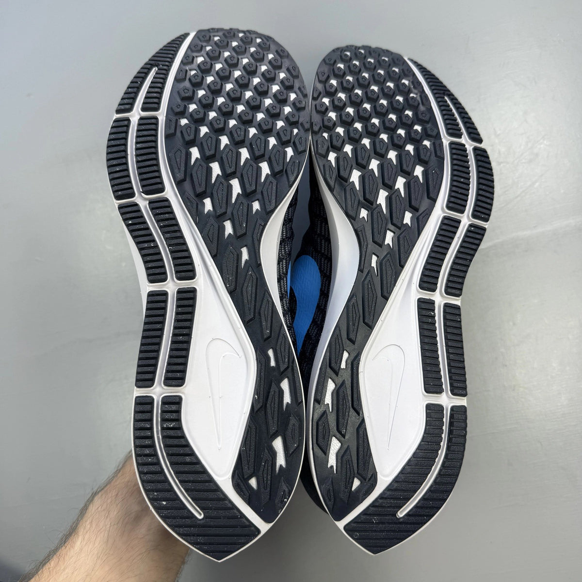Nike blue trainers with Air Zoom cushioning and logo detailing on the side.