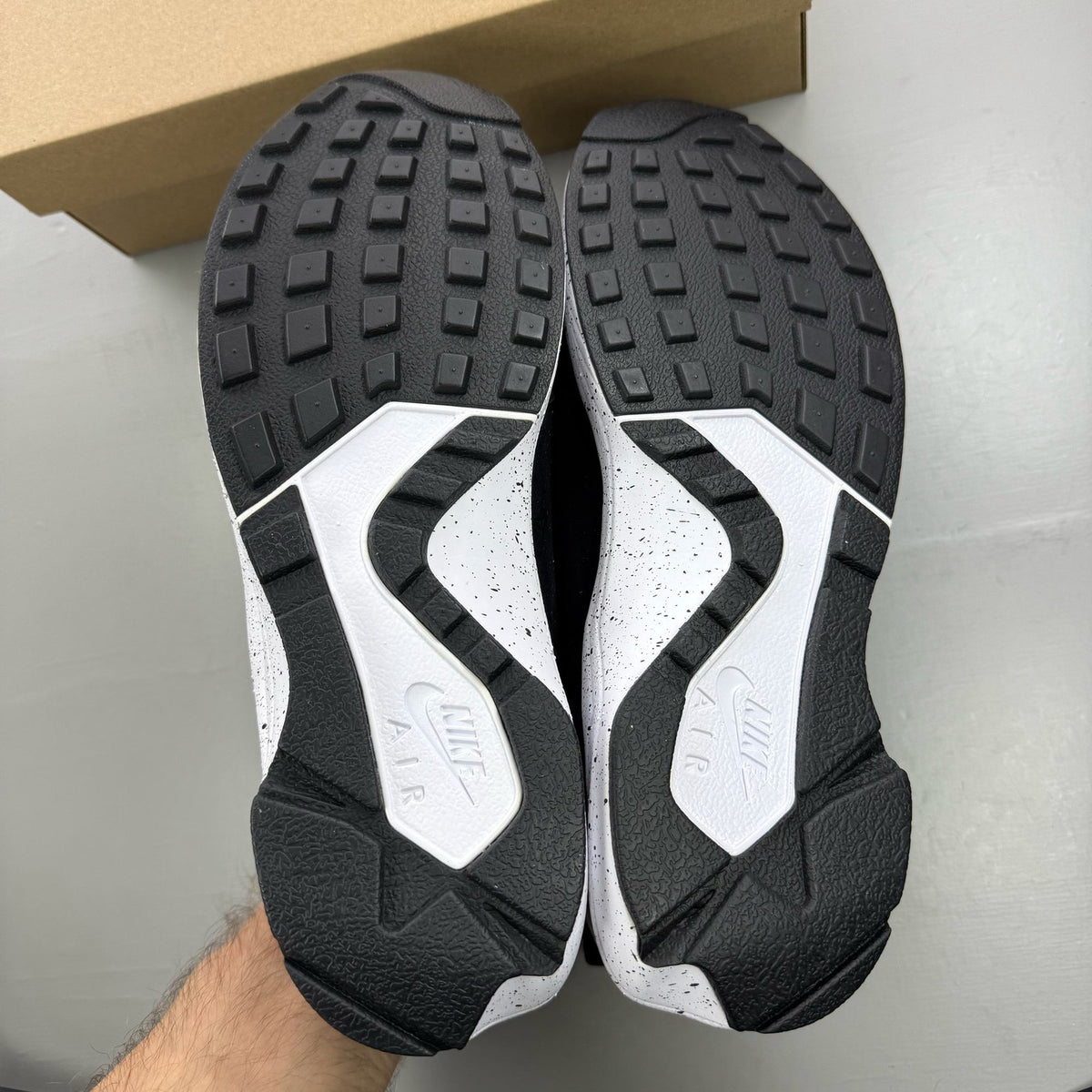 Nike black Air Huarache Light trainers with white accents and mesh detailing.
