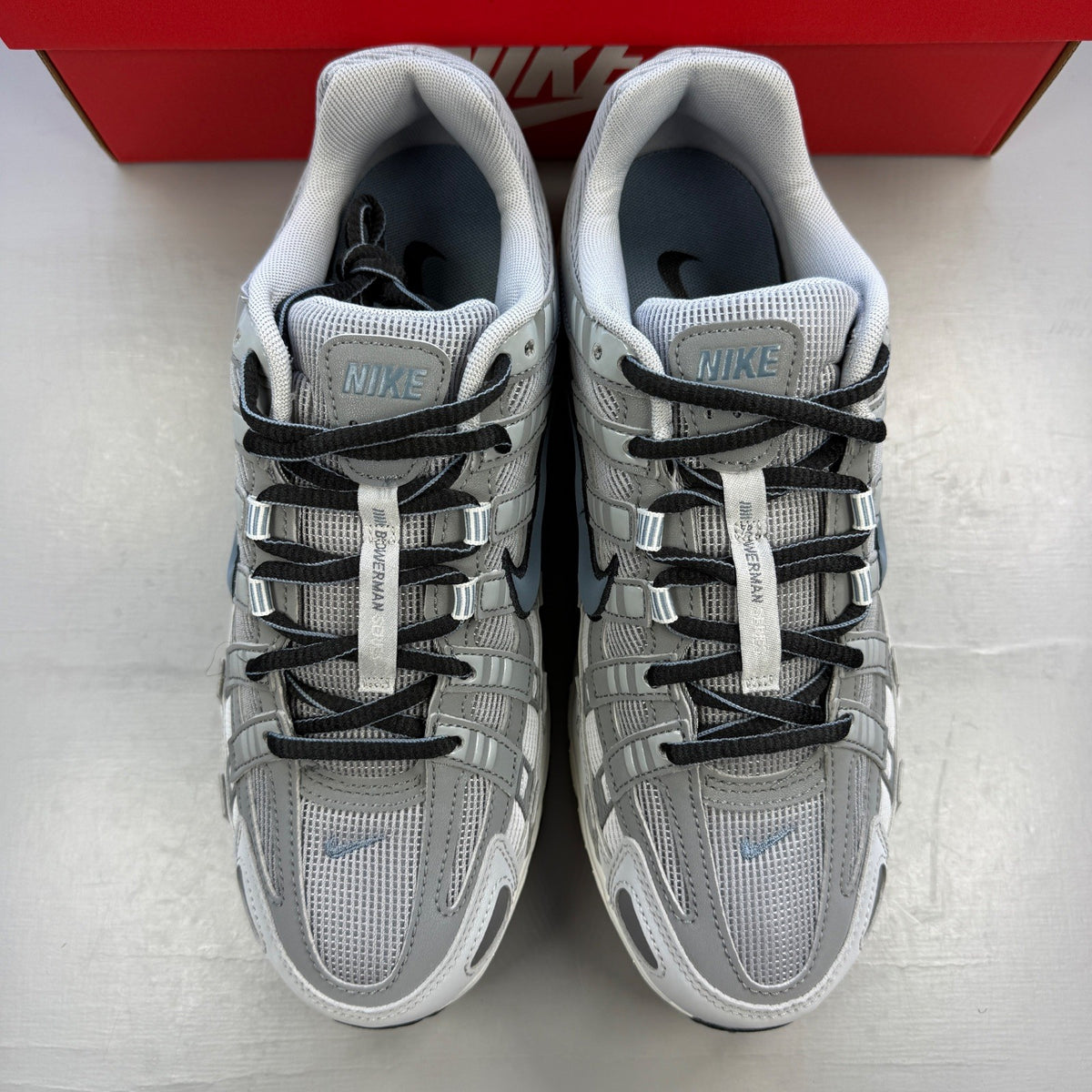 Nike athletic shoes light smoke grey with blue graphite accents and logo details.