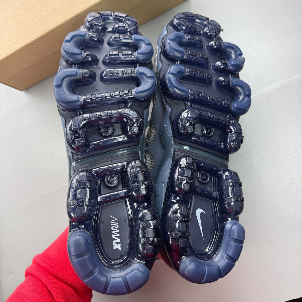Nike Air VaporMax Plus grey trainers with white accents and signature logo.