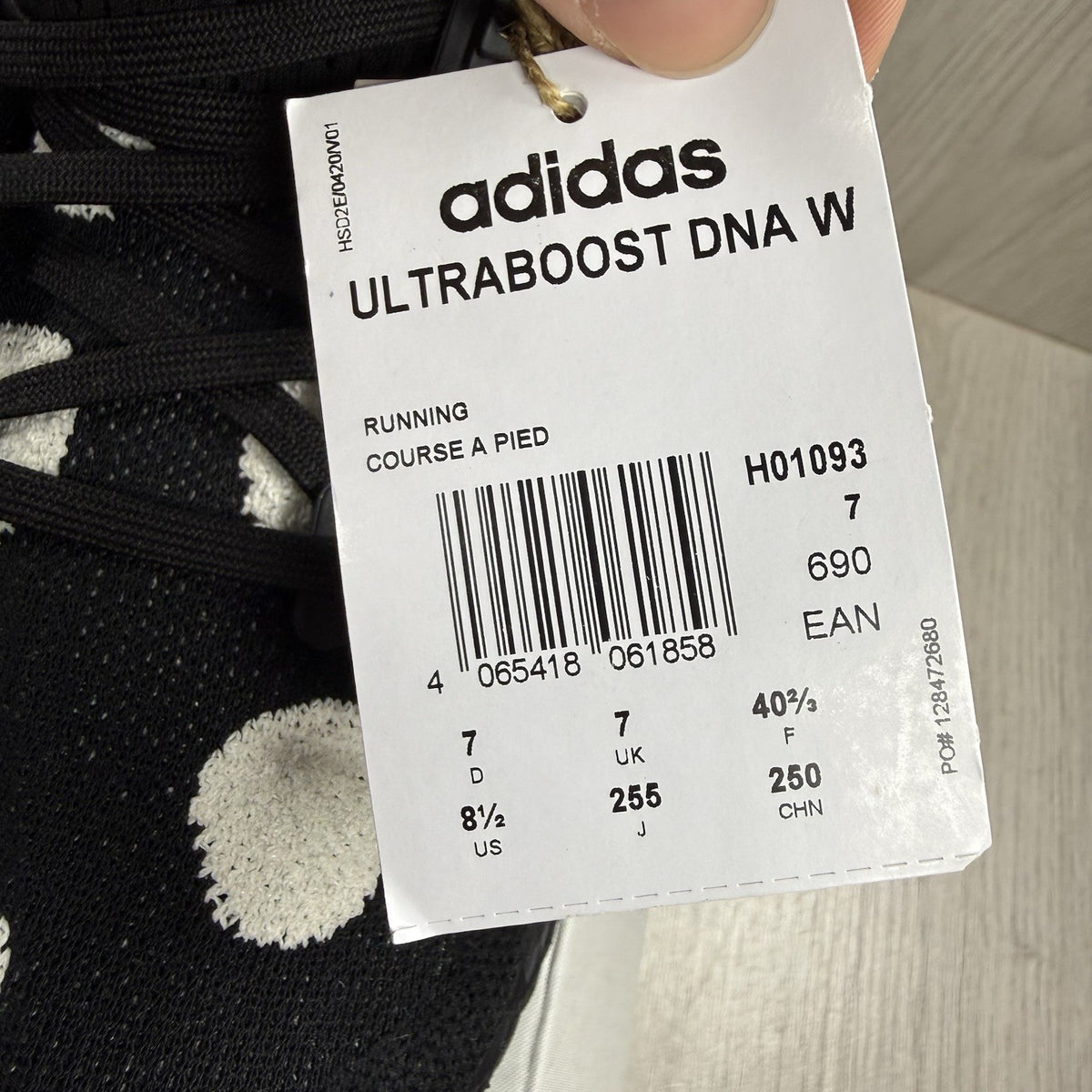Adidas black trainers with white polka dot pattern and iconic three-stripe logo.