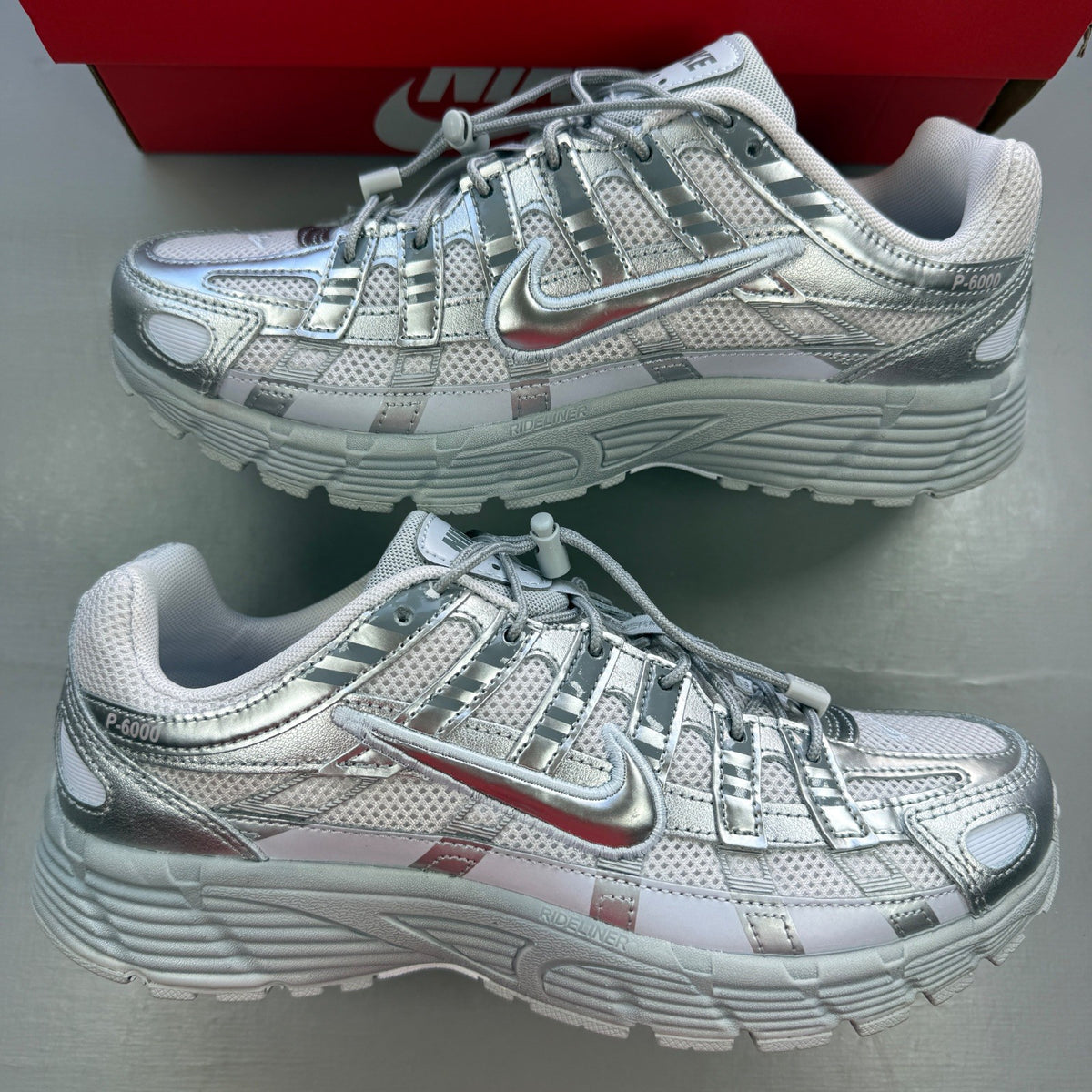 Nike deck shoes silver with logo details and sleek design.