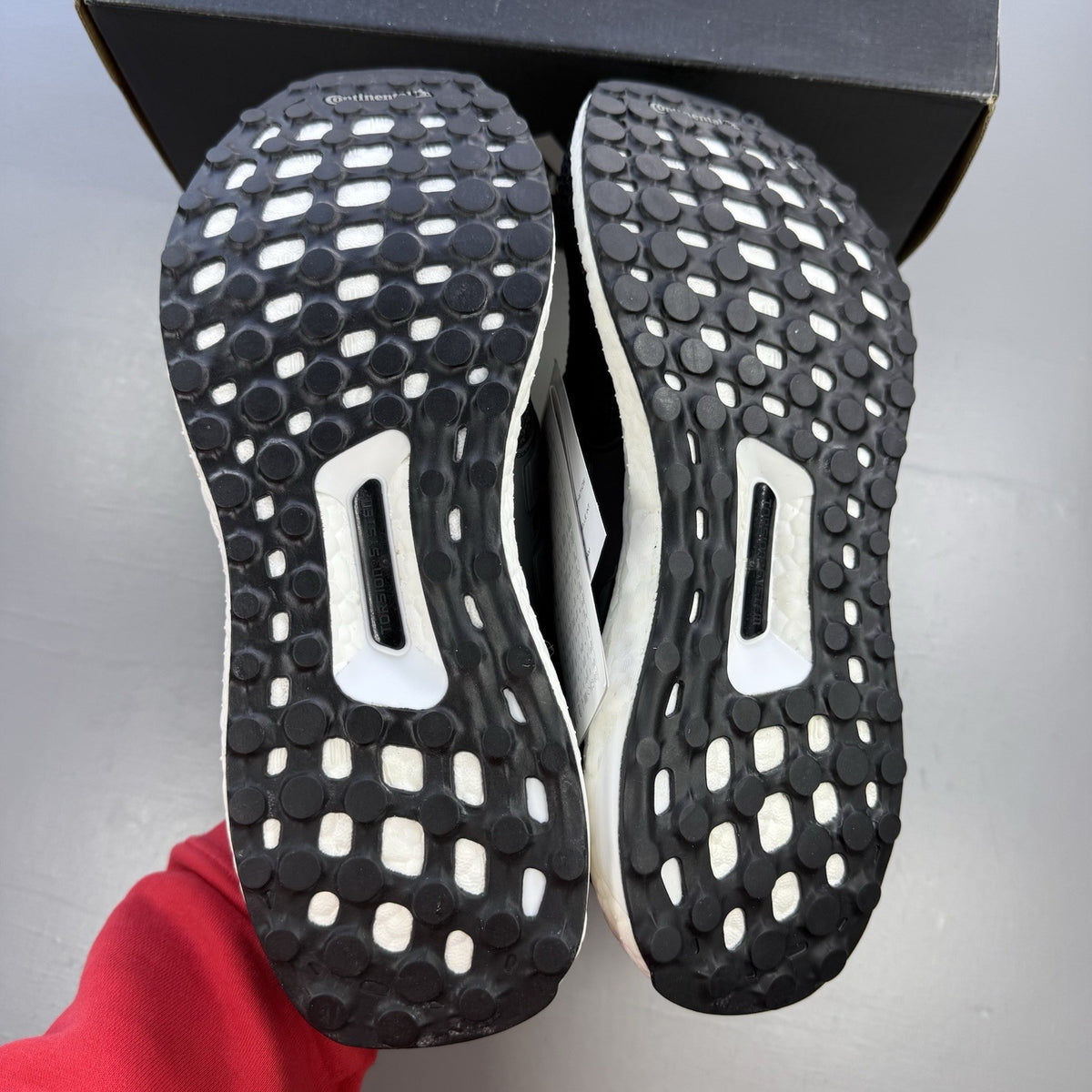Adidas black Ultra Boost trainers with white accents and signature three-stripe logo.