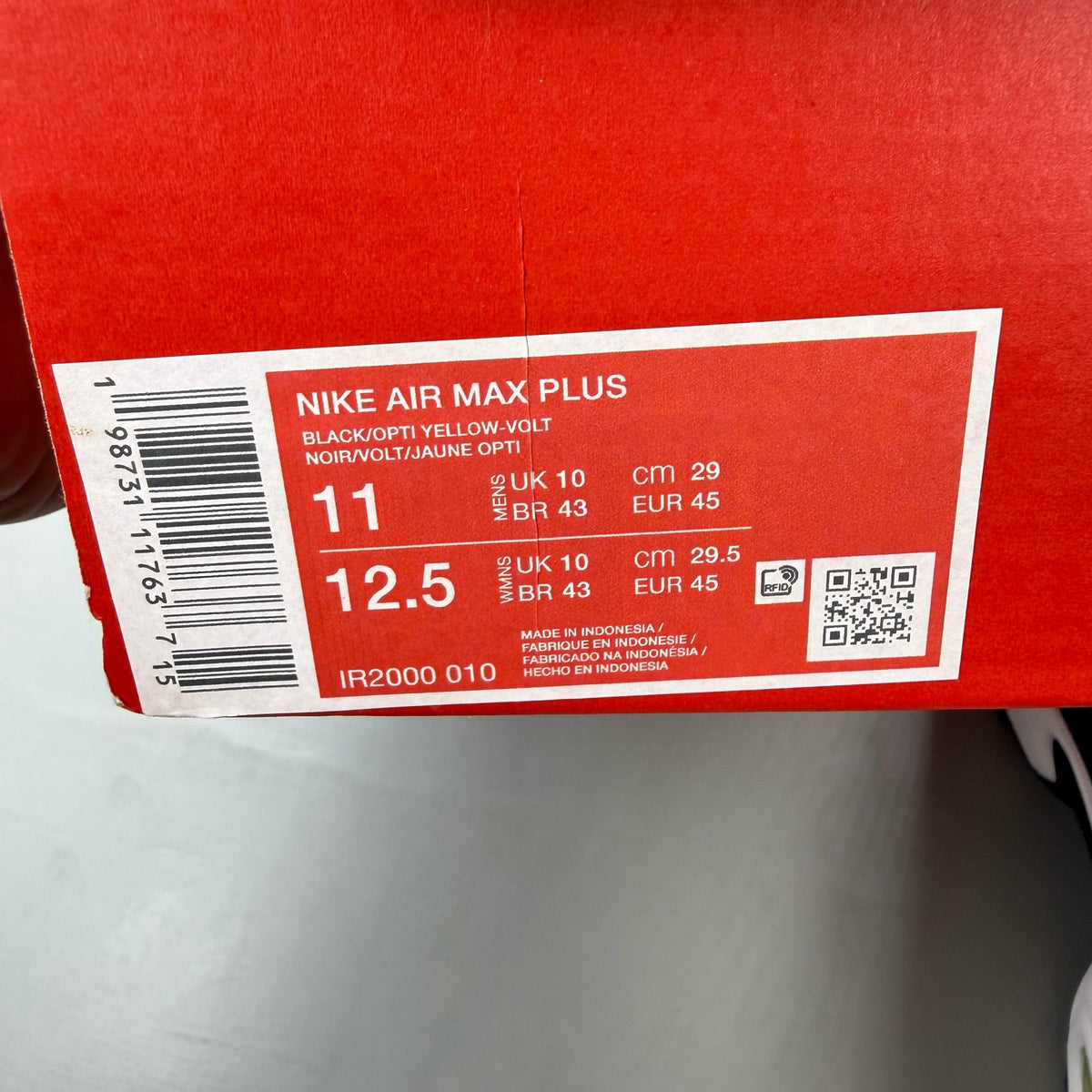 Nike Air Max Plus TN red trainers with black accents and vibrant volt detailing.