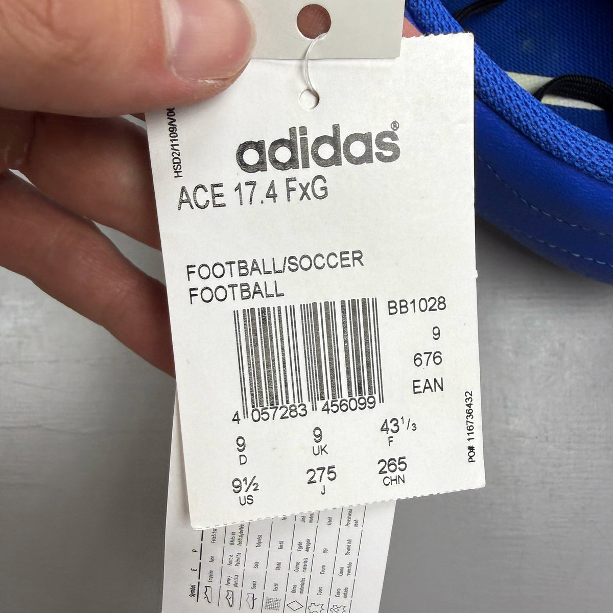 Adidas football boots white with blue and pink accents, featuring logo and textured material.