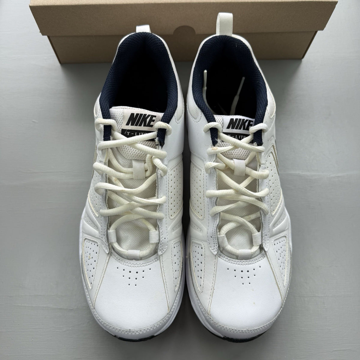 Nike T-Lite XI white trainers with obsidian and black accents, featuring a sleek design.