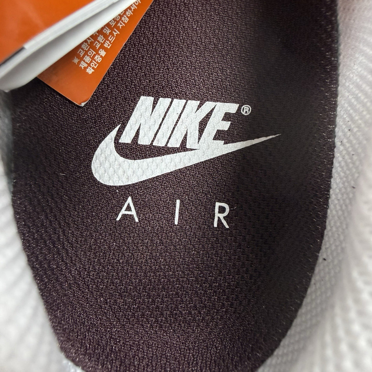 Nike Air Max 1 red trainers with white accents and signature swoosh logo.