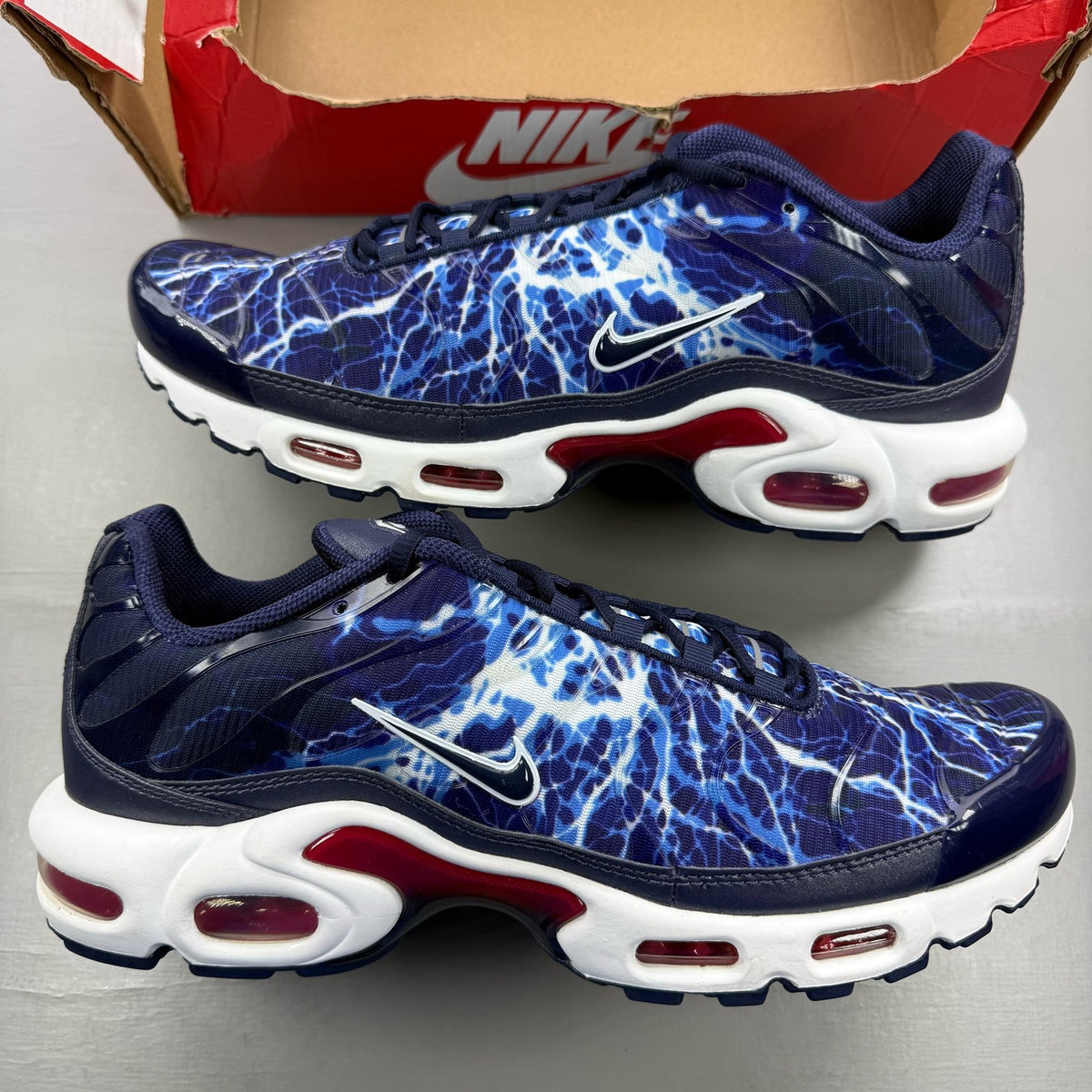 Nike Air Max Plus TN Eclair Lightning blue trainers with signature swoosh logo and mesh detailing.