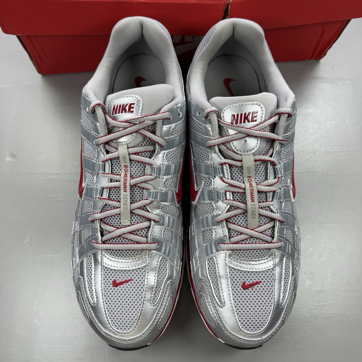 Nike P-6000 trainers in metallic silver with red and black accents, mesh upper.