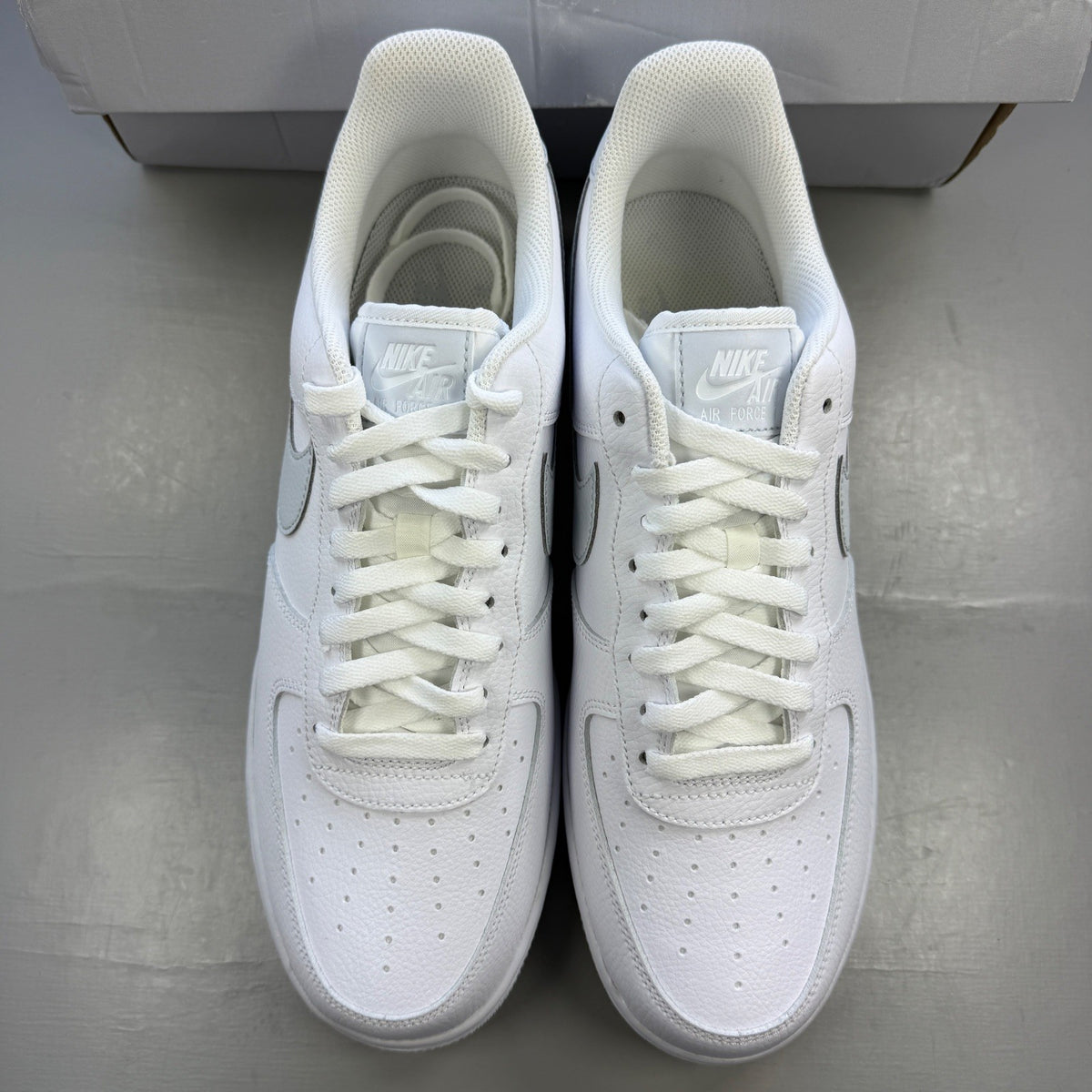 Nike Air Force 1 white trainers with pure platinum grey accents and classic logo.