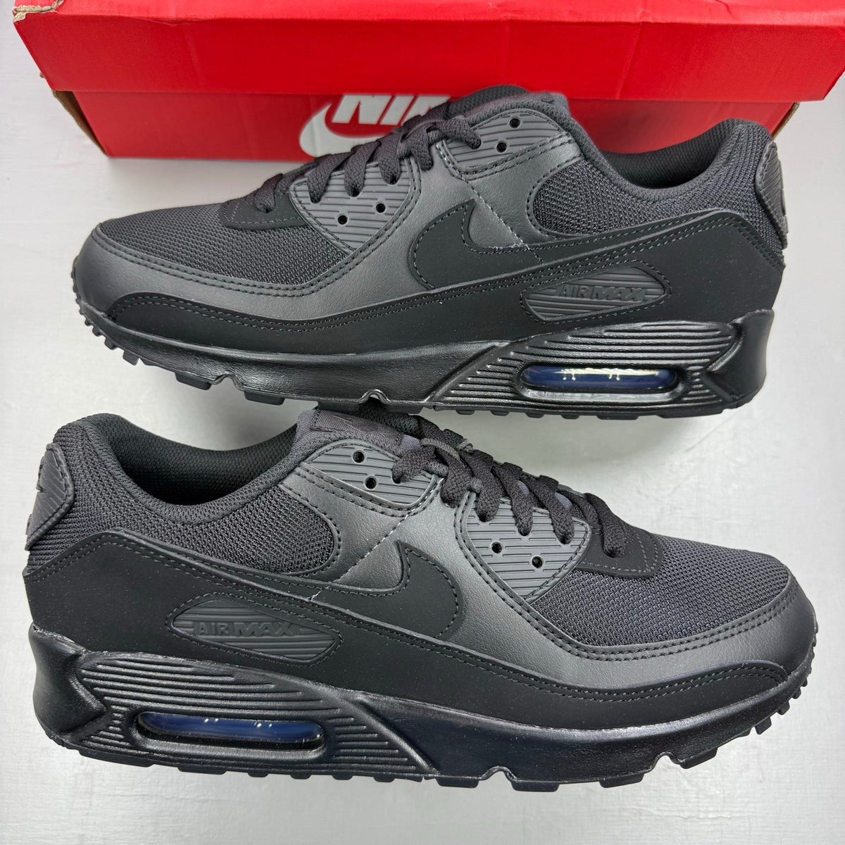 Nike black deck shoes with Air Max cushioning and sleek design.