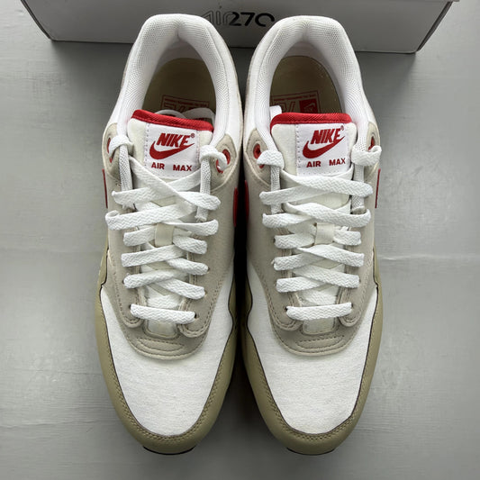 Nike Air Max 1 white trainers with red accents and classic logo detailing.