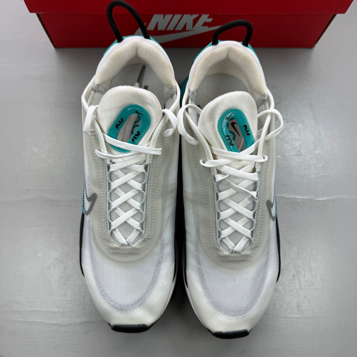 Nike trainers white with black and blue accents, featuring Air Max cushioning and logo.