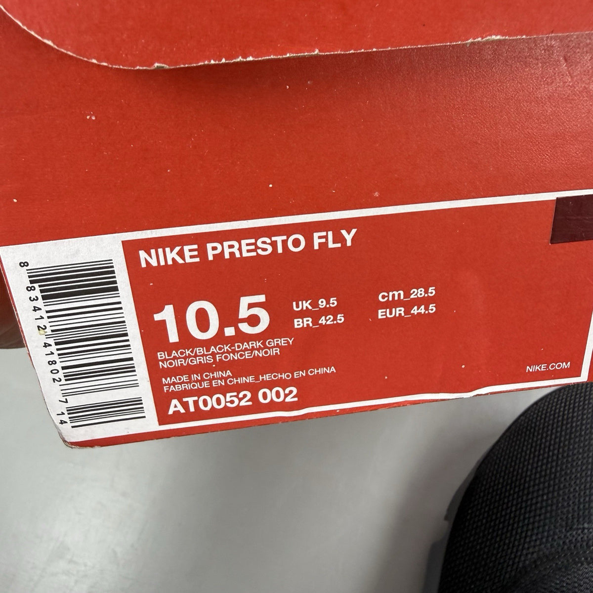 Nike Presto Fly black trainers with dark grey accents and logo detail.