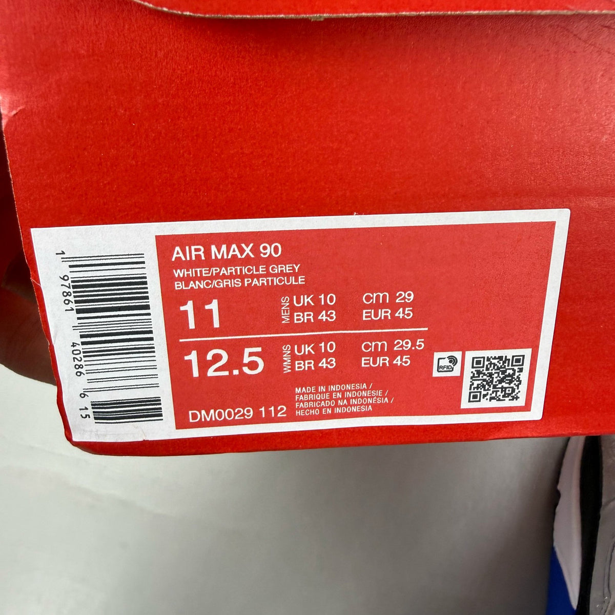 Nike Air Max 90 white trainers with hyper royal blue and grey accents.