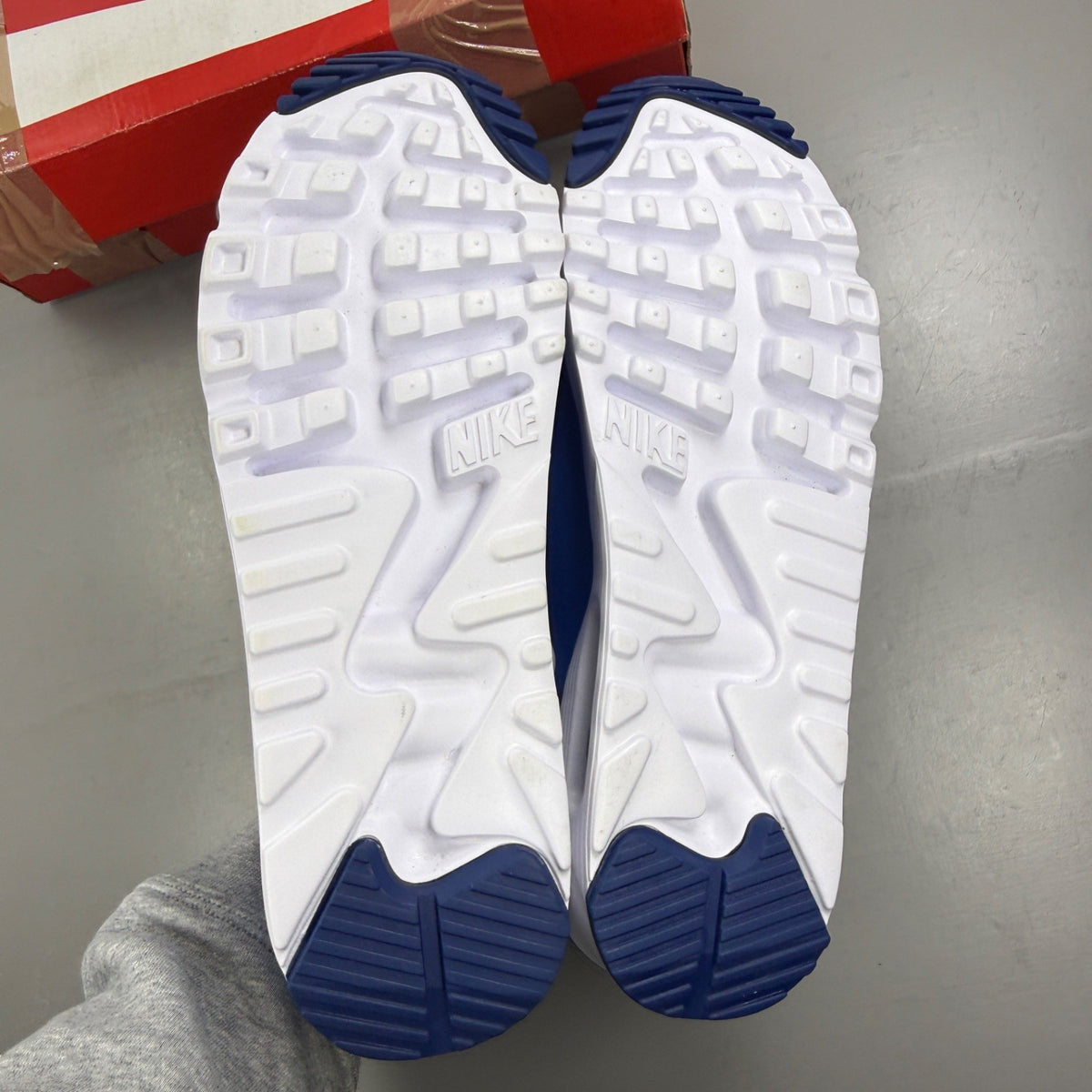 Nike Air Max 90 blue trainers with white accents and signature swoosh logo.