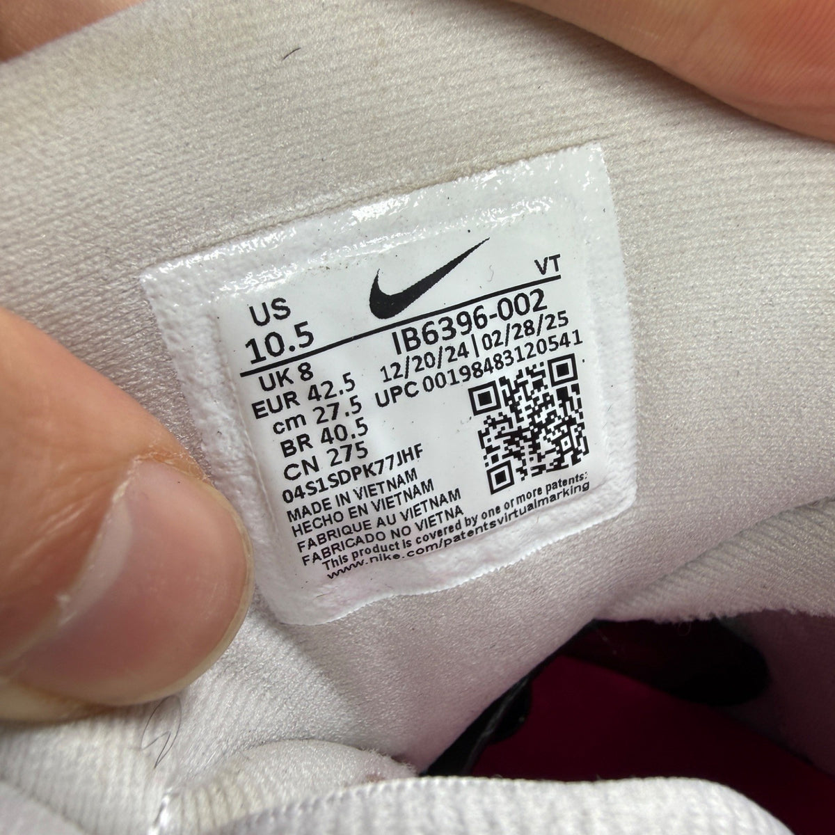 Nike running shoes white with pink accents and visible logo details.