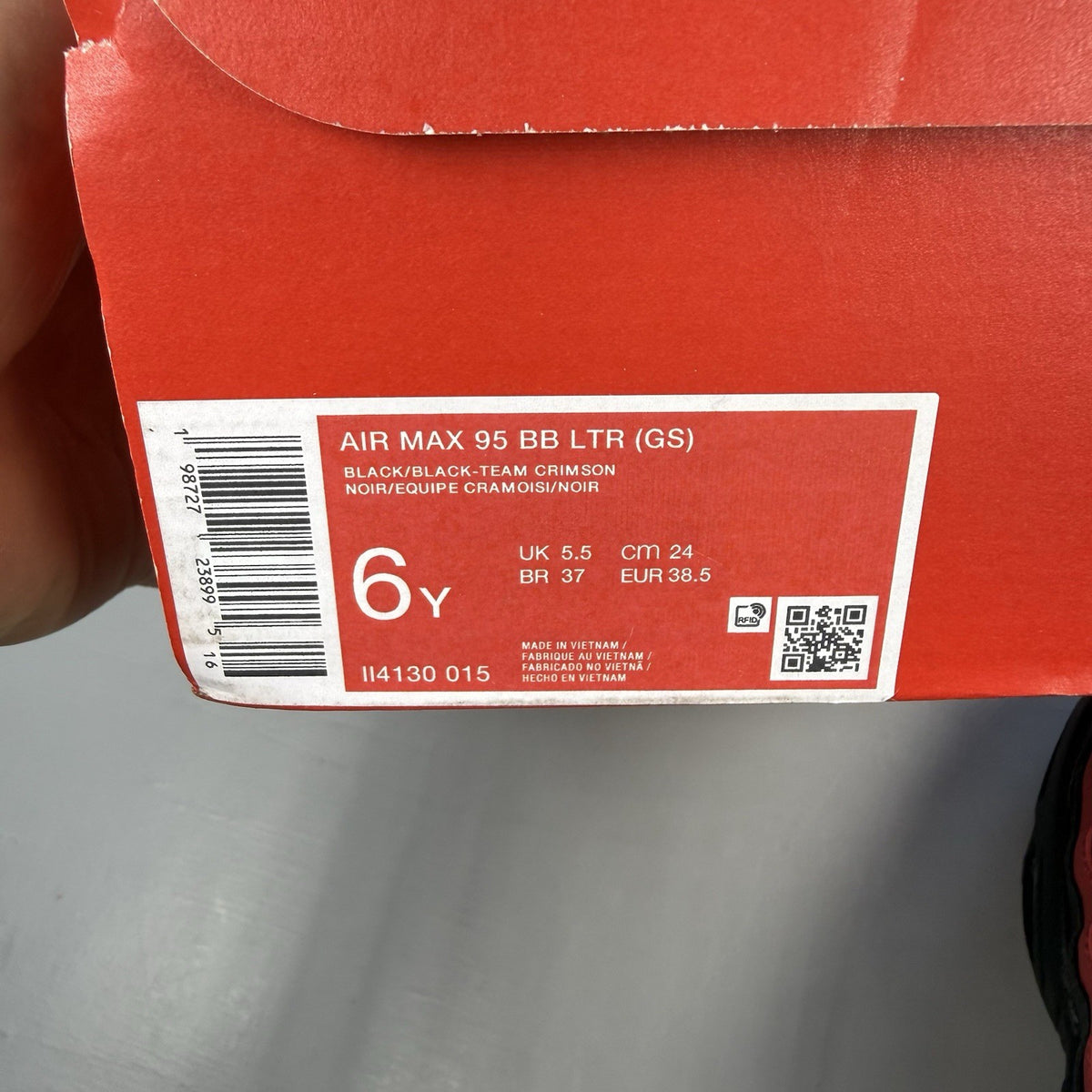 Nike Air Max 95 black trainers with crimson red accents and grey detailing.
