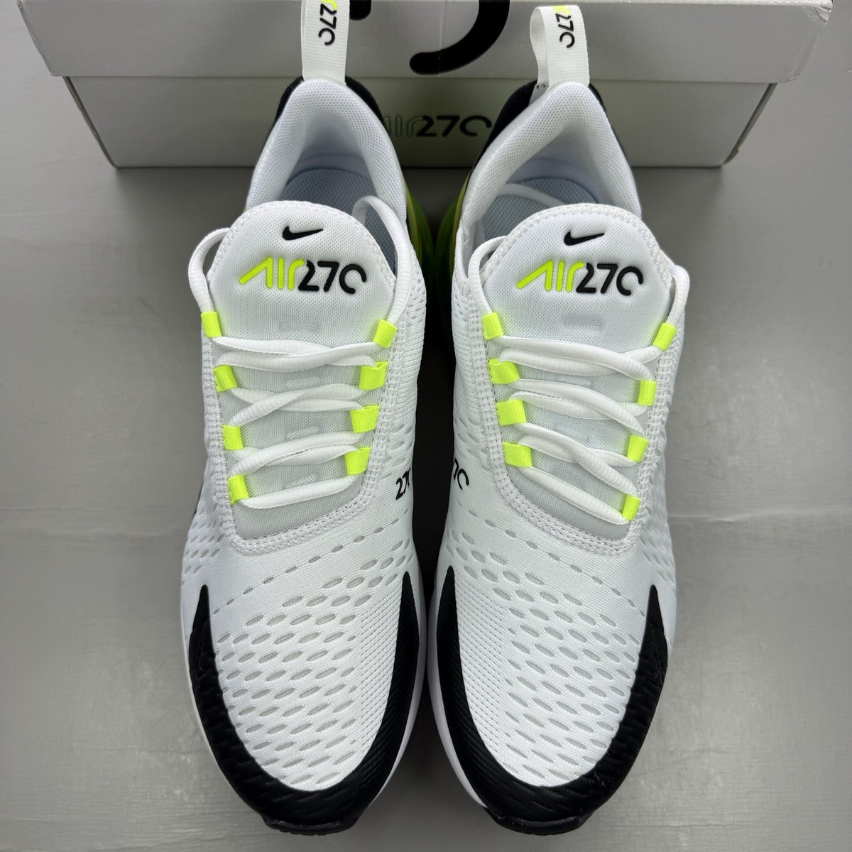 Nike Air Max 270 black trainers with white and volt green accents, mesh material.