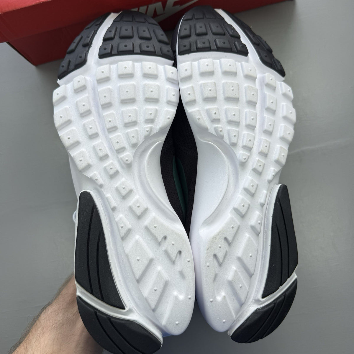 Nike Presto Fly black trainers with grey accents and white sole, featuring logo details.