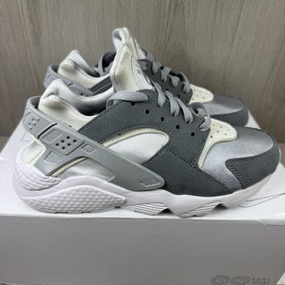 Nike white trainers with grey accents and signature logo on the tongue.