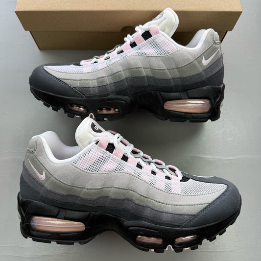 Nike Air Max 95 grey trainers with pink foam accents and black detailing.