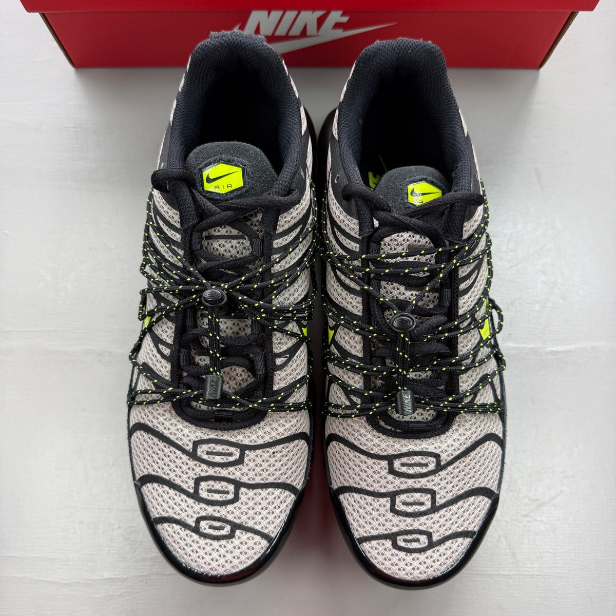 Nike Air Max Plus TN black grey volt with signature logo and sleek design.