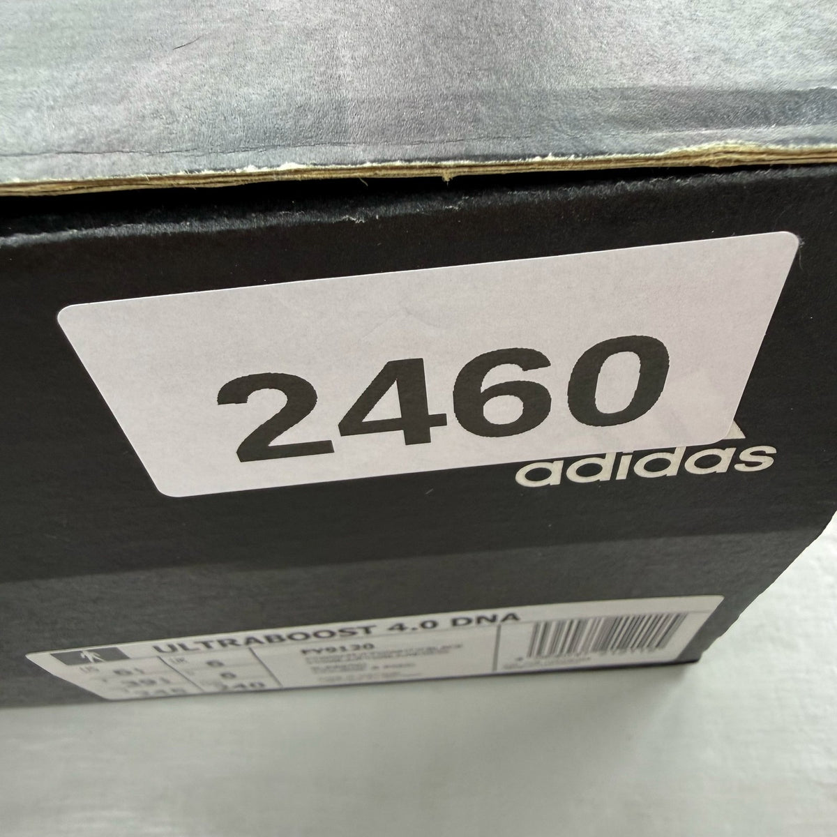 Adidas Ultra Boost 4.0 DNA white trainers with black accents and signature three-stripe logo.