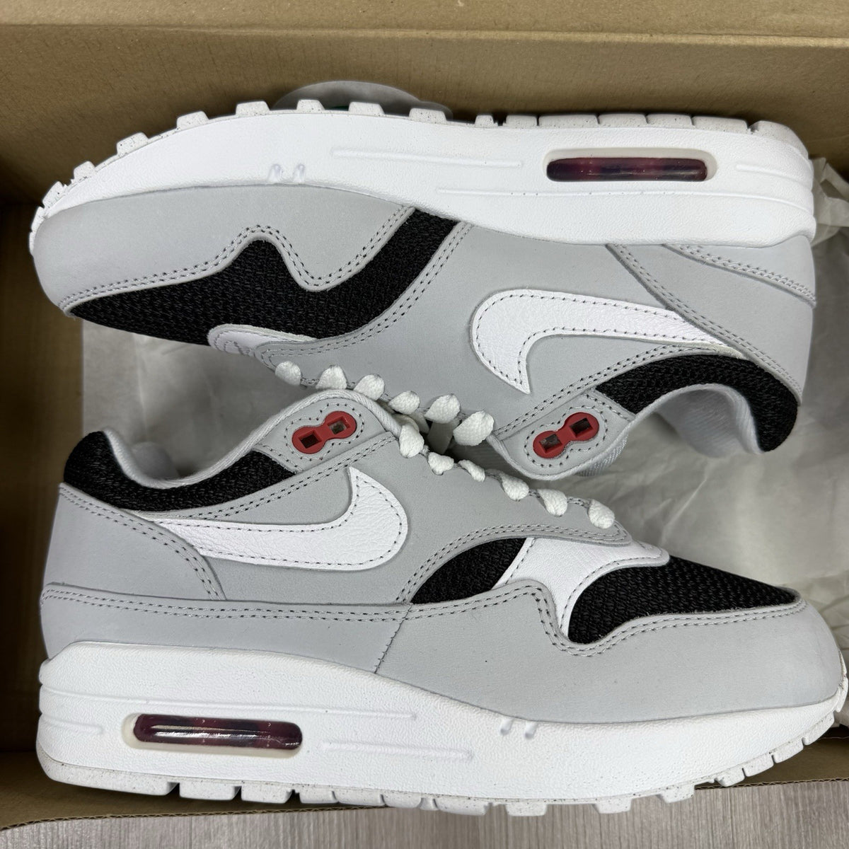 Nike Air Max 1 trainers grey with white accents and signature swoosh logo.
