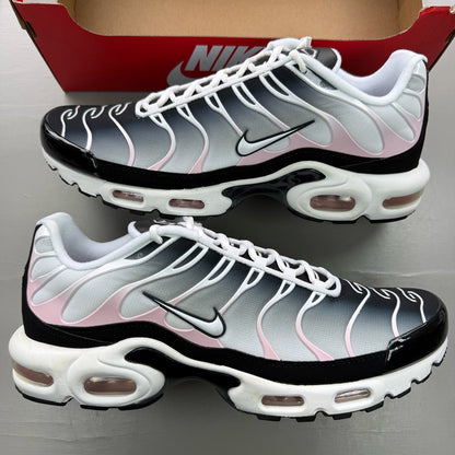 Nike Air Max Plus TN black trainers with pink accents and signature swoosh logo.