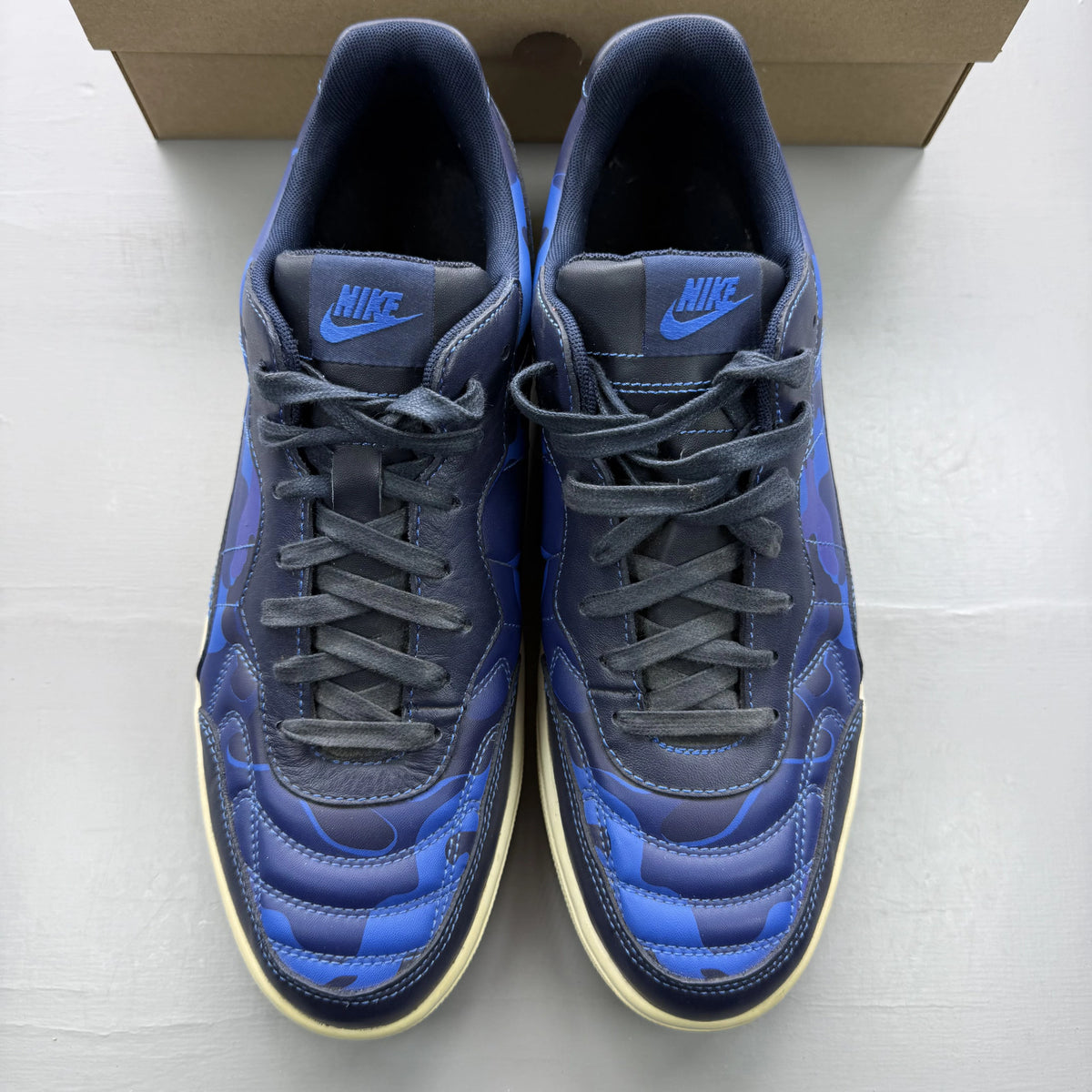 Nike blue trainers with obsidian camo pattern and logo detail.