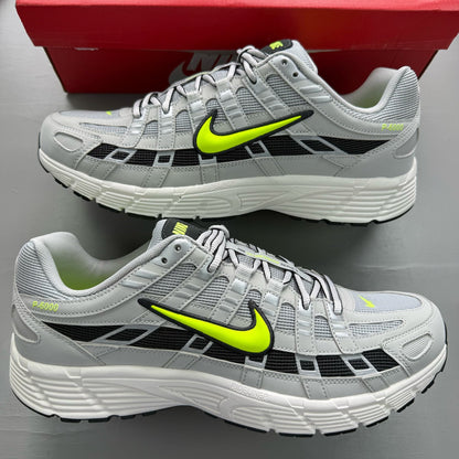 Nike P-6000 grey trainers with black accents and volt details, featuring iconic swoosh logo.