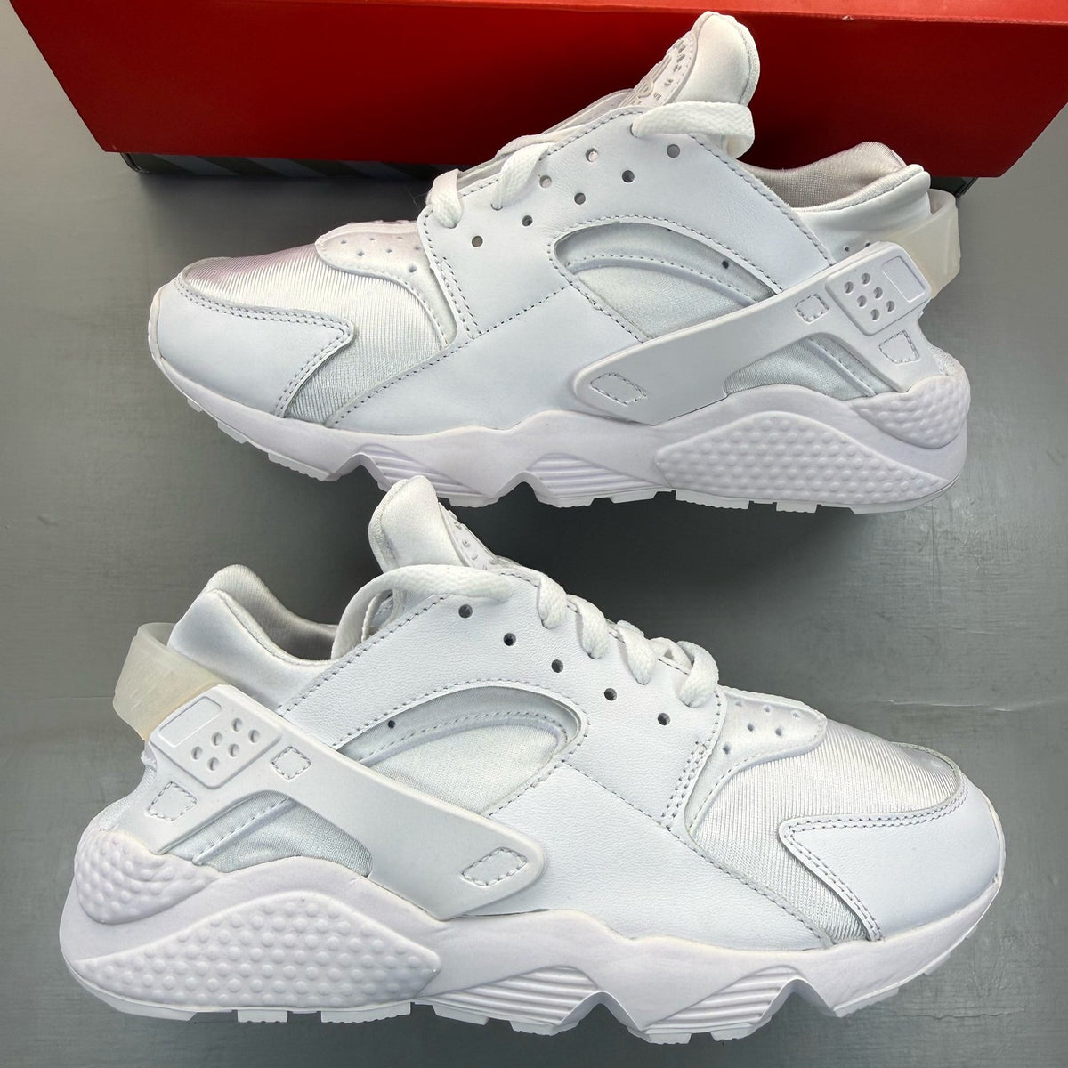Nike Air Huarache white trainers with textured upper and signature logo detail.