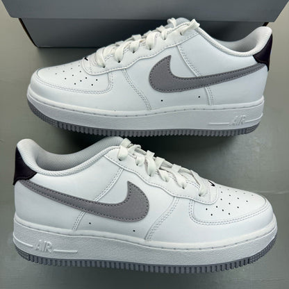Nike Air Force 1 low white trainers with grey cement accents and logo detailing.