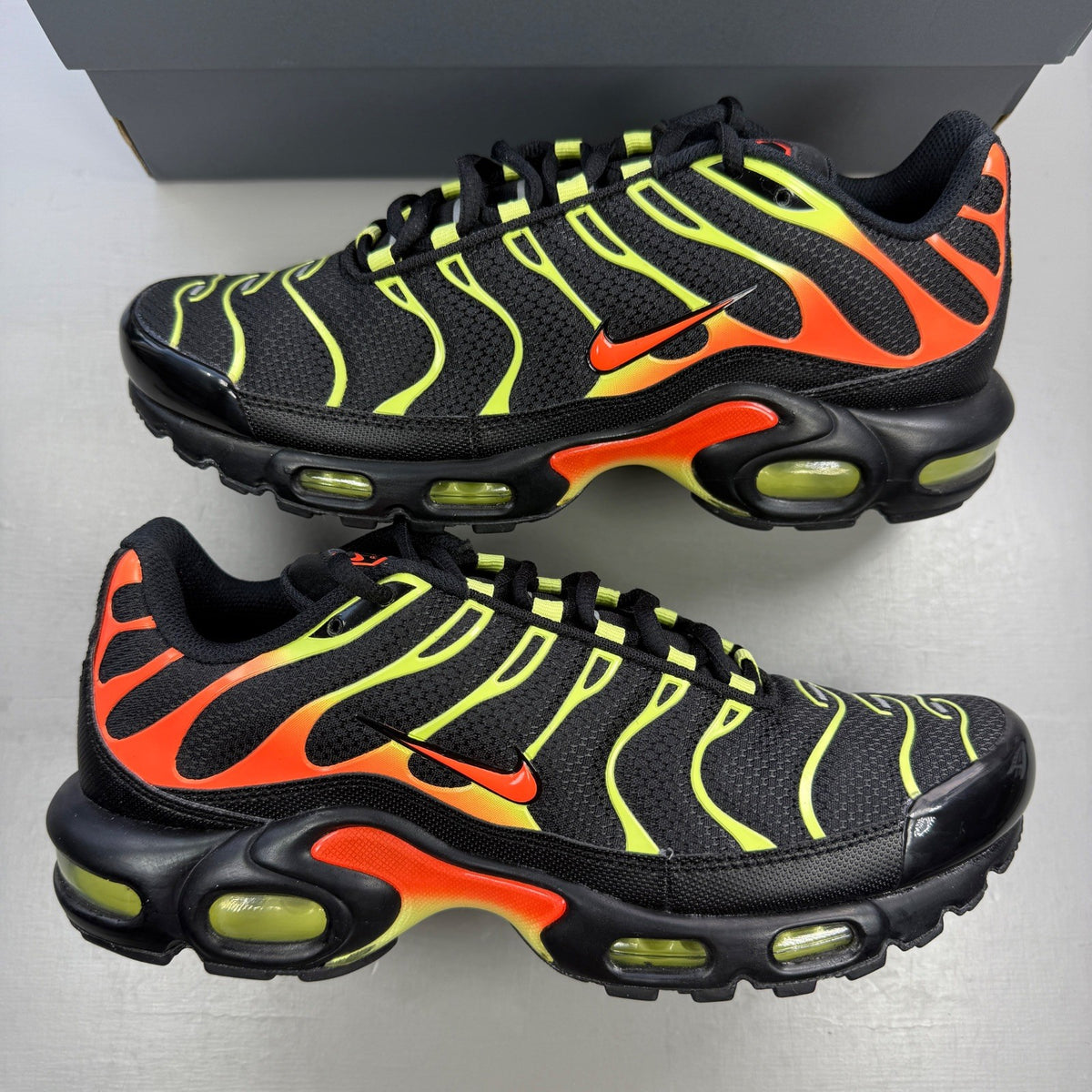 Nike Air Max Plus TN black with vibrant limelight and hyper crimson accents.