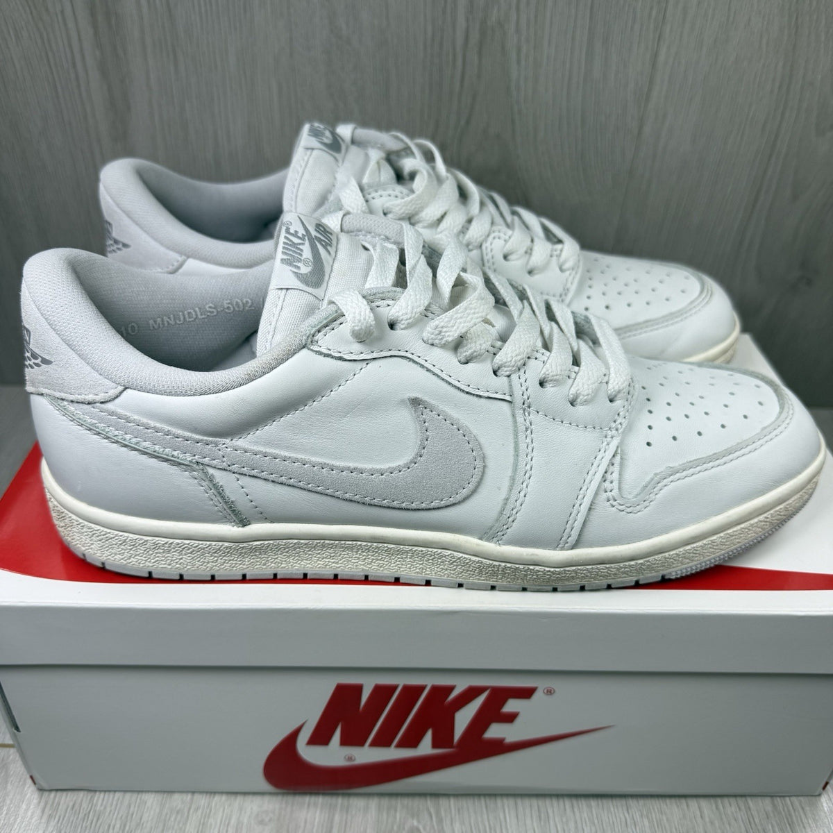 Nike Air Jordan 1 Low 85 grey trainers with white accents and iconic swoosh logo.