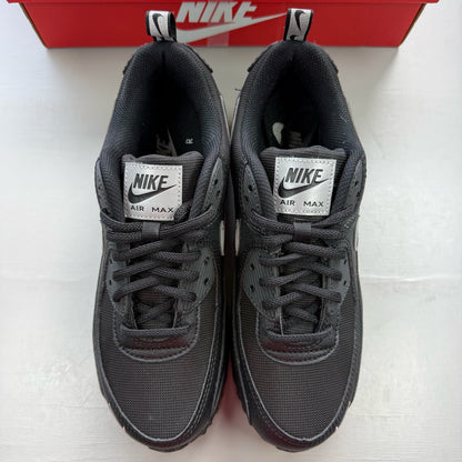 Nike black trainers with metallic silver swoosh logo and sleek design.