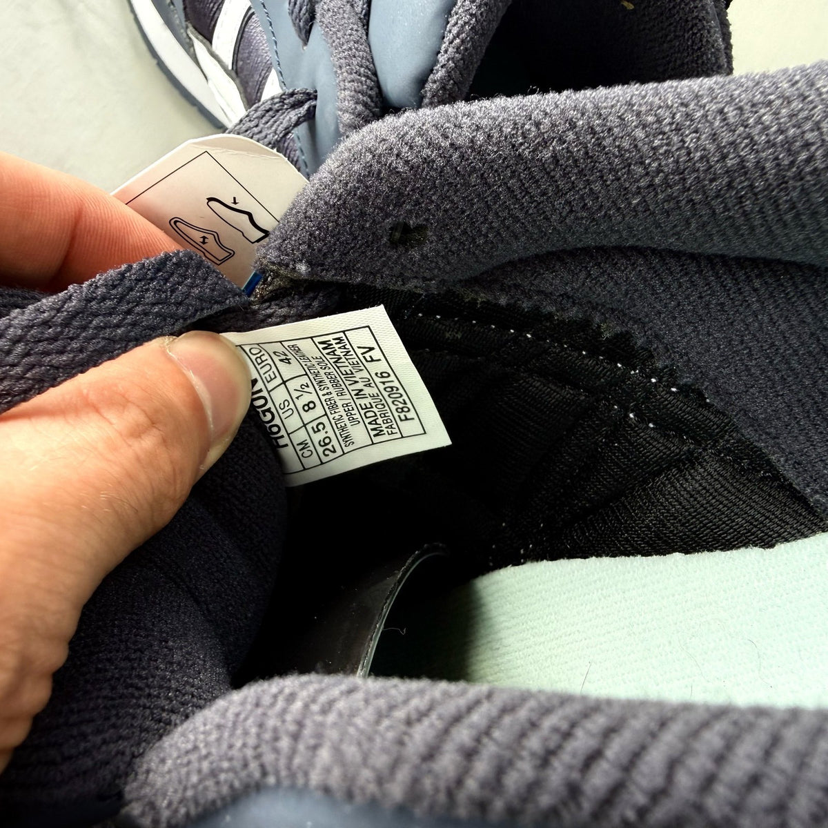 ASICS blue trainers with white accents and logo detail on the side.