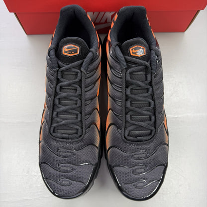 Nike Air Max Plus TN black trainers with total orange accents and signature logo.
