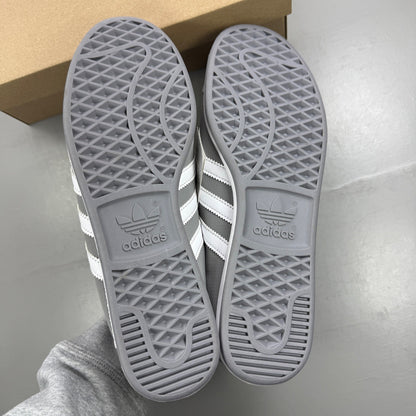 Adidas grey deck shoes with white accents and classic logo detailing.