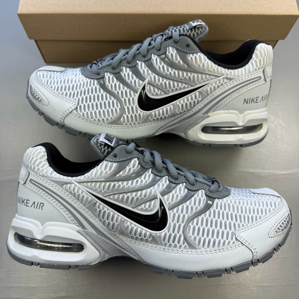 Nike Air Max Torch 4 grey and white trainers with mesh upper and signature swoosh logo.