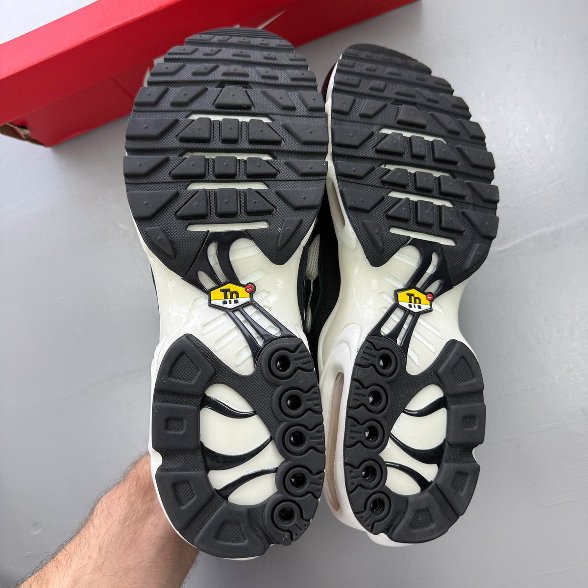 Nike Air Max Plus TN trainers white with black accents and signature logo.