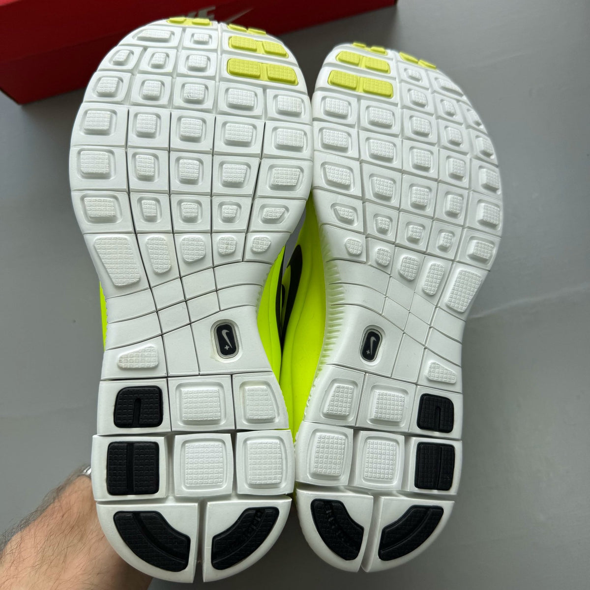 Nike grey trainers with black accents and distinctive Free 5.0 design.