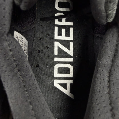 Adidas black trainers with white accents and distinctive Adizero branding.