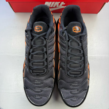 Nike Air Max Plus TN black trainers with total orange accents and signature logo.