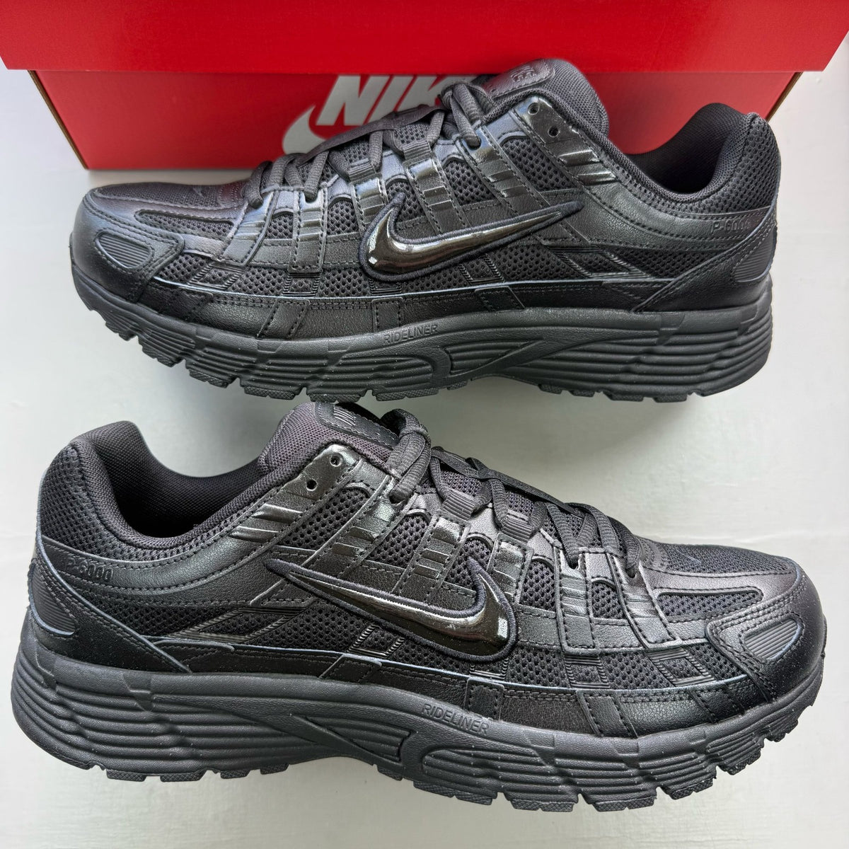 Nike black trainers with mesh upper and signature swoosh logo.