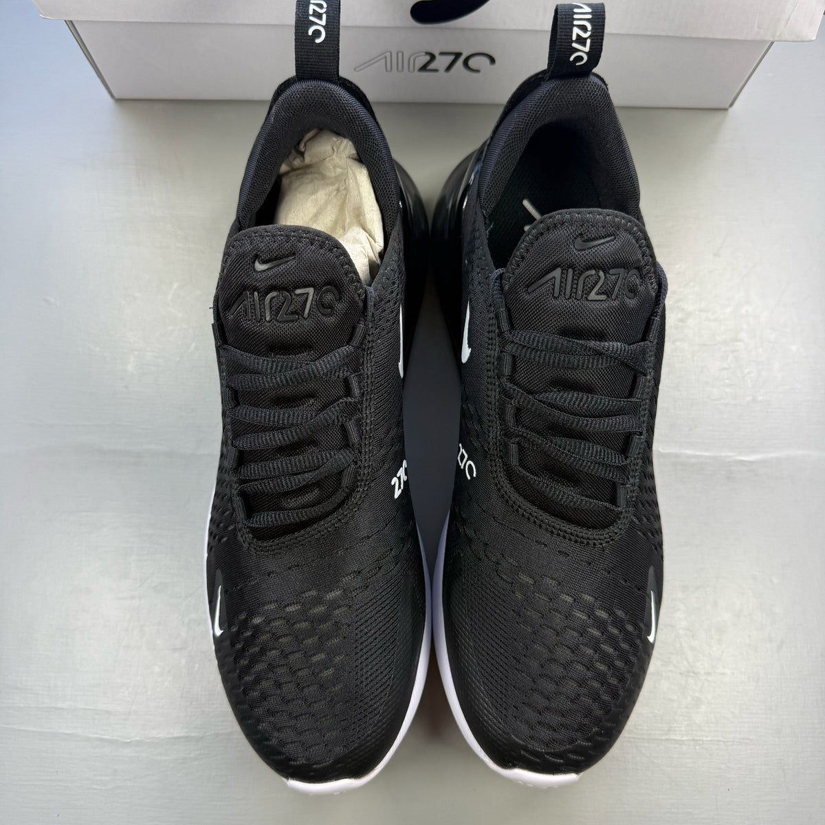 Nike black Air Max 270 trainers with white accents and logo detail.