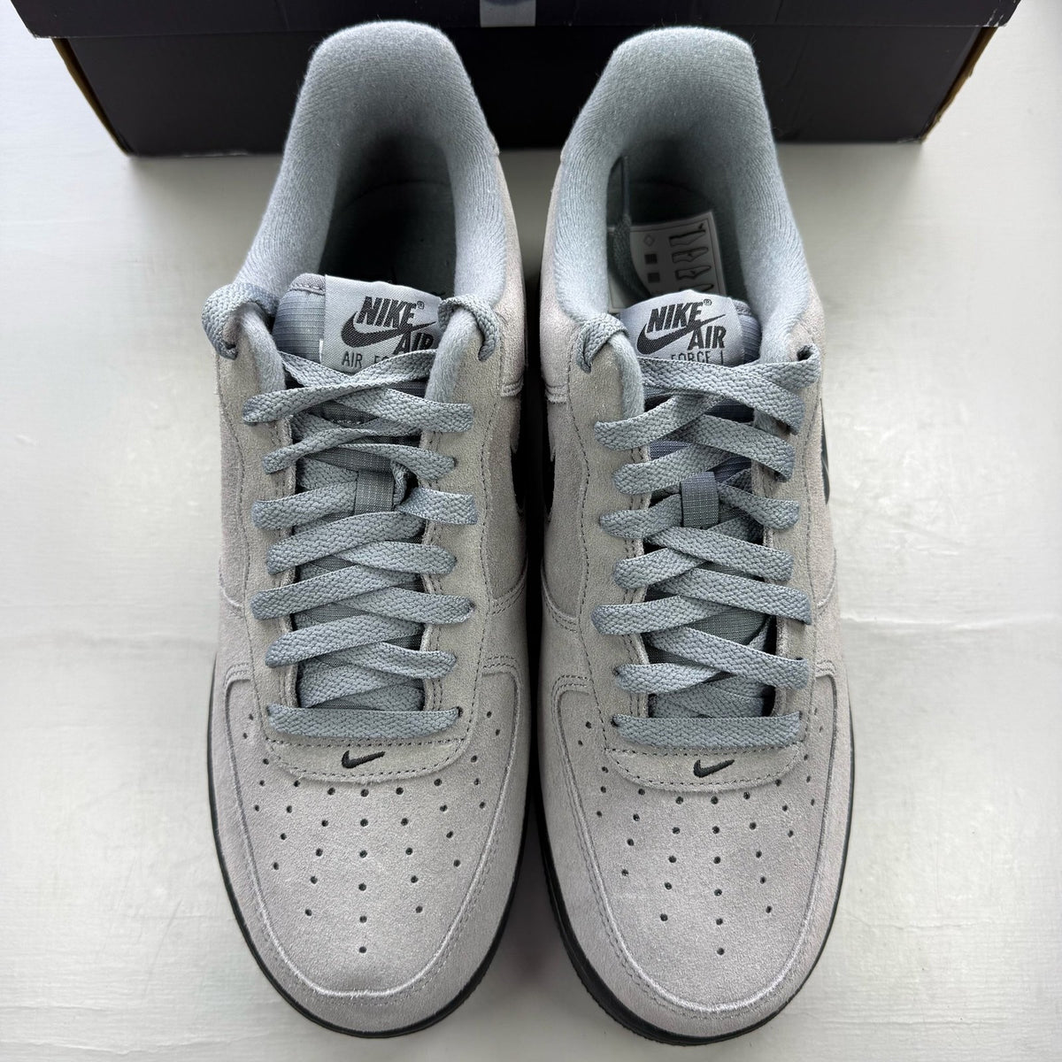 Nike Air Force 1 grey trainers with black accents and jewel logo detail.