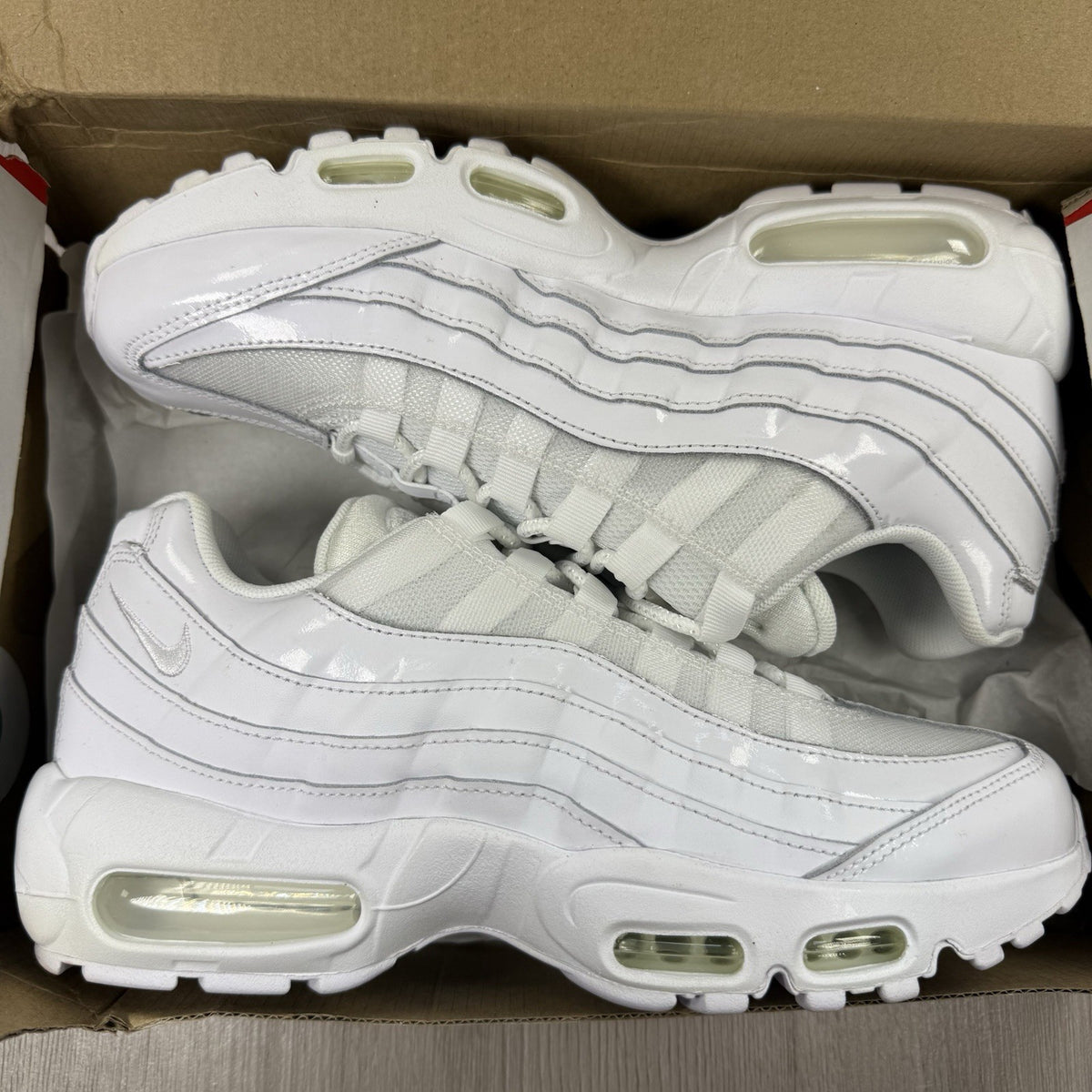 Nike Air Max 95 trainers white mesh upper with signature swoosh logo and reflective details.
